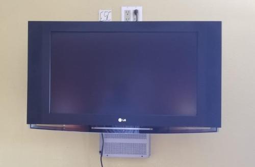 a flat screen tv hanging on a wall at Western Motel in El Centro