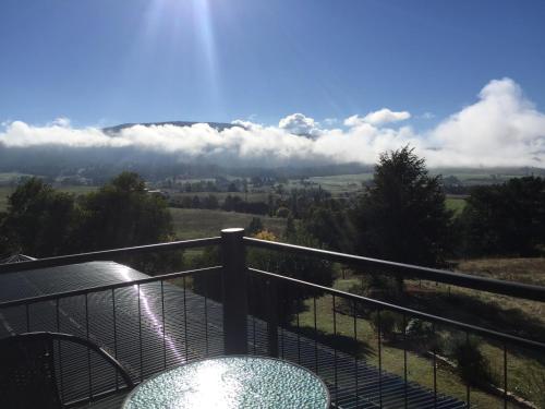a balcony with a view of the hills and clouds at Rosewhite House in Myrtleford