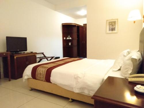 a hotel room with a bed and a television at Excelsior Resort in Dili