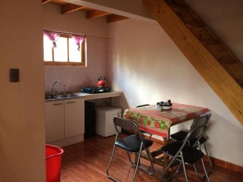 a kitchen with a table with chairs and a sink at Refugio Don Natu in San Pedro de Atacama
