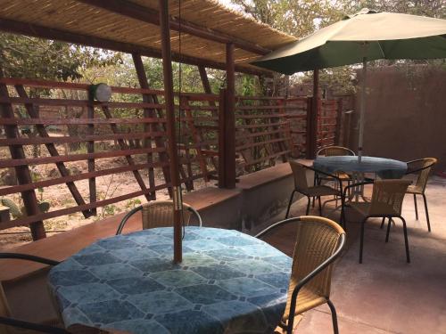 a table and chairs and an umbrella on a patio at Refugio Don Natu in San Pedro de Atacama