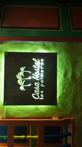 a sign for a restaurant on a wall at casa hostal las palmeras in Guatapé