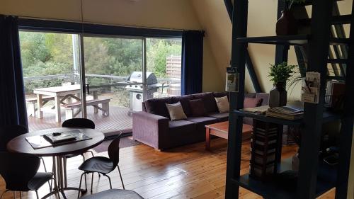 a living room with a couch and a table at The A-Frame in Halls Gap