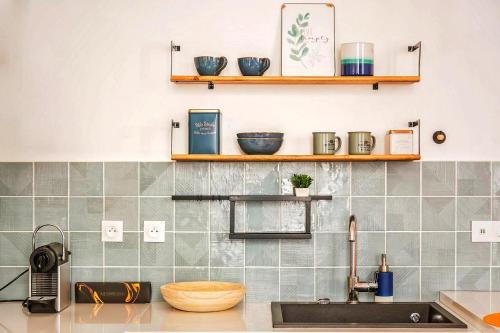une cuisine avec un évier et des étagères murales dans l'établissement Amazing Apartment Notre Dame Boulevard St-Germain - 4 Bedrooms, à Paris