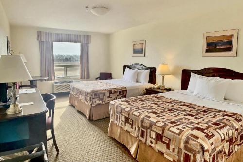 una camera d'albergo con due letti e una finestra di Prairie Moon Inn & Suites Unity a Unity