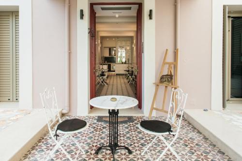 um quarto com uma mesa e cadeiras e um corredor em La Canea Canvas 1 em Chania Town