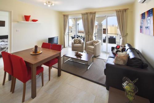 a living room with a table and a dining room at Club St. George in Paphos City