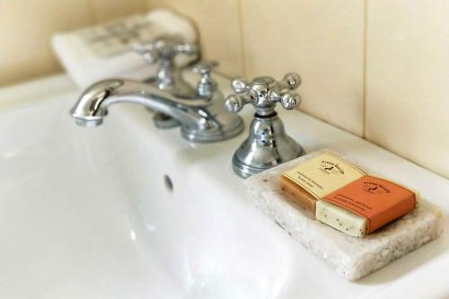 un lavabo con grifo y un libro sobre él en River Valley Lodge, en Taihape