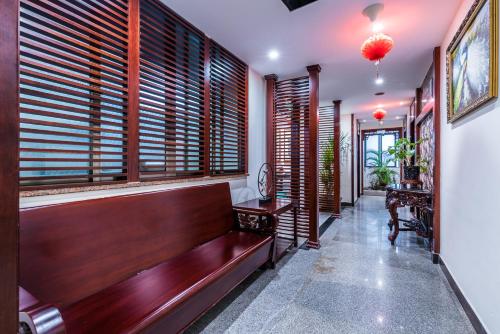 a hallway with a wooden bench and windows at Hainan Jingshan Hotel in Haikou