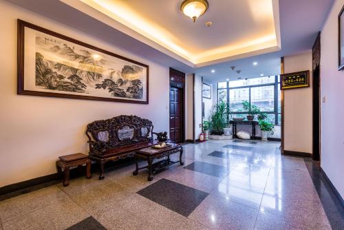 a living room with a couch and a painting on the wall at Hainan Jingshan Hotel in Haikou