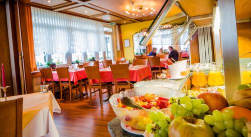 a restaurant with a table with a bowl of fruit at Hotel Heilquelle-Leukerbad-Therme in Leukerbad