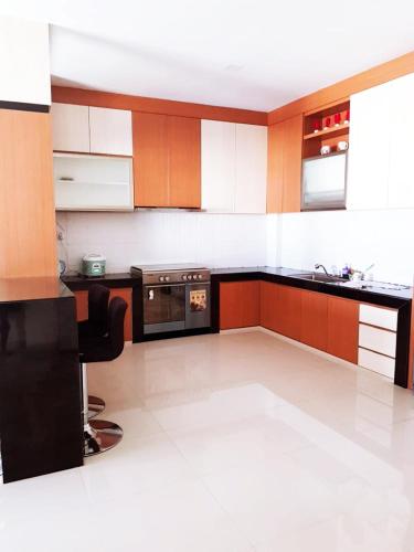 a kitchen with brown and white cabinets and a stove at Jakson Homestay in Batam Center