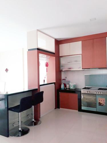 a kitchen with red and white cabinets and a chair at Jakson Homestay in Batam Center