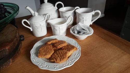 a table with a plate of food and a group of cups at Dragonflycottagebnb in Grovetown
