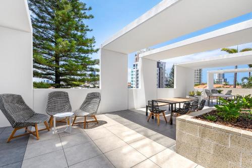 a patio with chairs and a table on a patio at Qube Broadbeach in Gold Coast