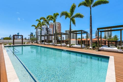 a swimming pool on a building with palm trees at Qube Broadbeach in Gold Coast