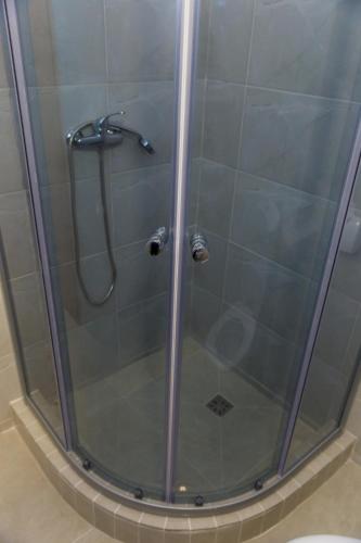 a shower with a glass door in a bathroom at Ema in Vama Veche