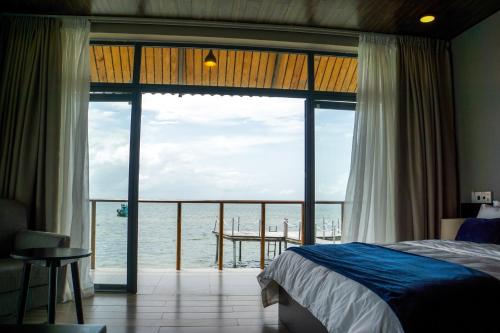 a bedroom with a bed and a view of the ocean at The Pier Phu Quoc Resort in Phu Quoc