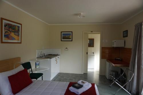 sala de estar con cama y cocina en Abel Tasman Haven en Marahau