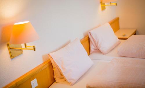 a room with two beds with a lamp and a lamp at Hotel Heilquelle-Leukerbad-Therme in Leukerbad