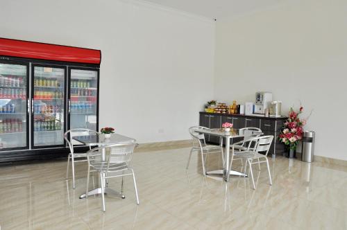 un restaurant avec des tables, des chaises et un comptoir dans l'établissement Hotel Raub Agro, à Raub