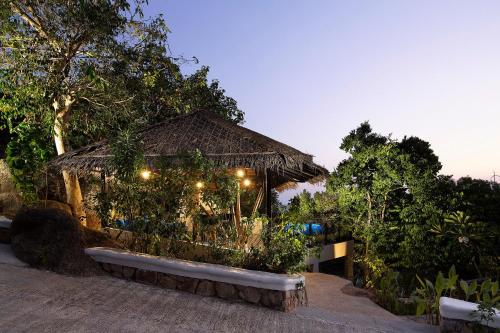a building with a straw hut with lights at Pahili Pool Villas Koh Tao - SHA Plus in Koh Tao