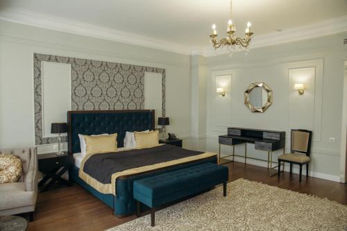 a bedroom with a bed and a chair and a mirror at Royal BV in Ustʼ-Kamenogorsk