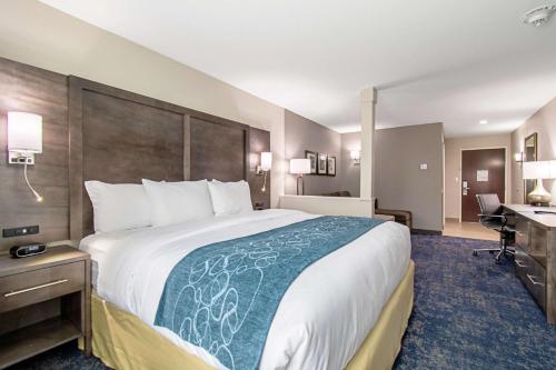 a hotel room with a large bed and a desk at Comfort Suites Humble Houston IAH in Humble