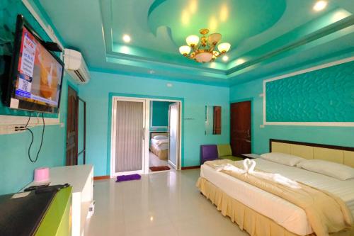 une chambre avec un grand lit et une télévision à écran plat dans l'établissement Rak Kun Resort 2, à Nakhon Sawan