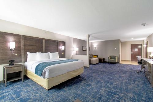 a hotel room with a large bed and a desk at Comfort Suites Humble Houston IAH in Humble