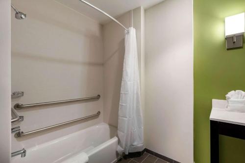 a bathroom with a tub and a shower curtain at Sleep Inn & Suites Tampa South in Tampa