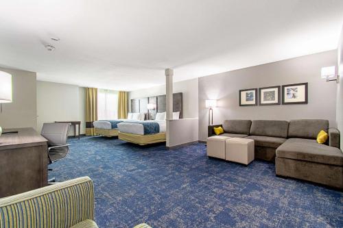 um quarto de hotel com um sofá e uma cama em Comfort Suites Humble Houston IAH em Humble