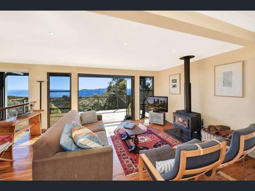 uma sala de estar com um sofá e uma lareira em Narrow Neck Views - Peaceful 4 Bedroom Home with Stunning Views! em Katoomba