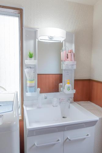 a kitchen with a white counter with a sink at Uhome Iriya Apartment in Tokyo