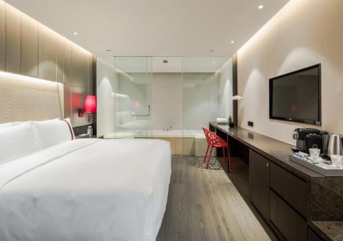 
a hotel room with a large bed and a television at Rhombus Park Aura Chengdu Hotel in Chengdu

