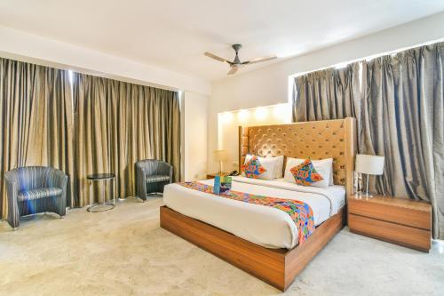 Habitación de hotel con 1 cama y 2 sillas en FabHotel Prime Sage, en Nueva Delhi
