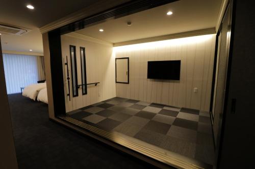 a room with a checkered floor and a television at Yado Hanasaku in Tateyama