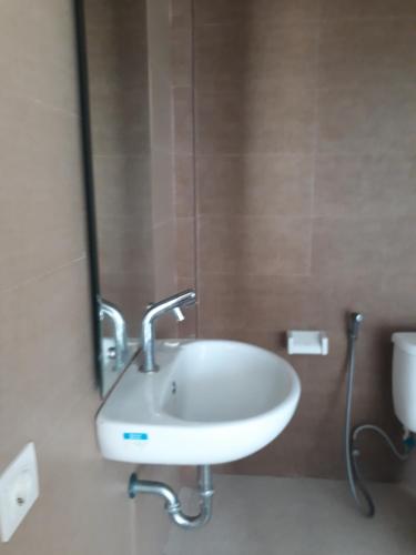 La salle de bains est pourvue d'un lavabo et d'un miroir. dans l'établissement Brielle guest house, à Jimbaran