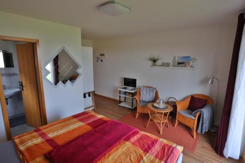 a bedroom with a bed and a chair and a table at Bellevue in Malente