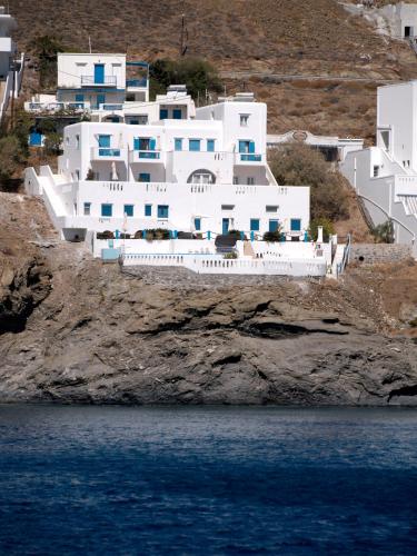 a white building on a cliff next to the water at Caldera Studios in Astypalaia Town