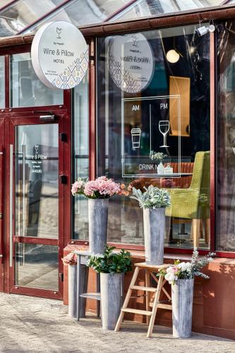 a store front with three vases with flowers in it at Wine&Pillow Hotel by Frapolli in Odesa
