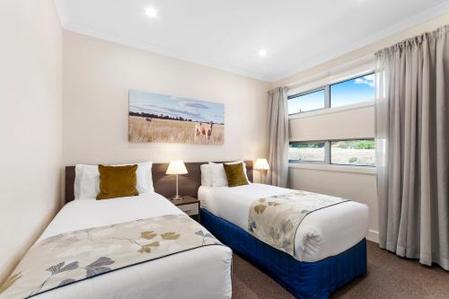 two beds in a room with a window at Comfort Inn & Suites Warragul in Warragul