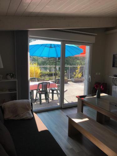 - un salon offrant une vue sur une terrasse avec un parasol dans l'établissement Les Terrasses de La Malcombe, à Besançon