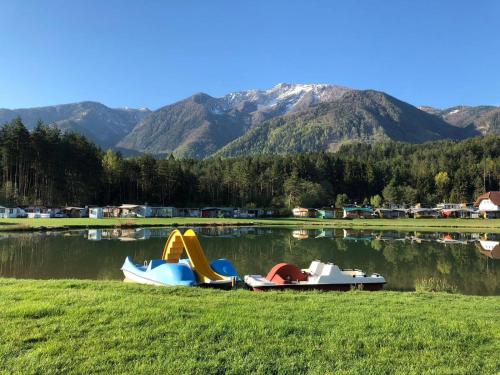 three inflatable water slides on the grass near a lake at Pension Pirkdorfer See in Sankt Michael ob Bleiburg