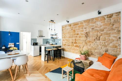 Il comprend un salon et une cuisine avec un mur en pierre. dans l'établissement Amazing Apartment Notre Dame Boulevard St-Germain - 4 Bedrooms, à Paris
