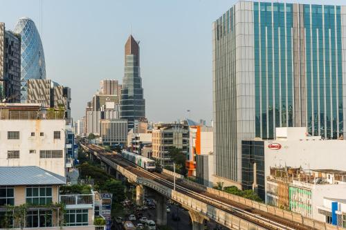 a city skyline with a train tracks and buildings at Vib Best Western Sanam Pao in Bangkok