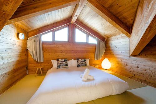 sypialnia w drewnianym domku z dużym łóżkiem w obiekcie Wadano Gateway Suites & Apartments w mieście Hakuba