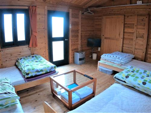 Habitación con 3 camas en una cabaña de madera en Koinami en Shima