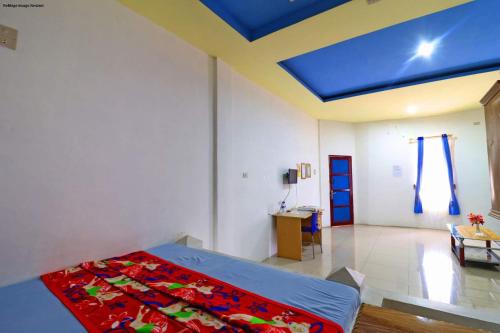 a bedroom with a bed and a blue ceiling at Hotel Rembulan in Tebingtinggi