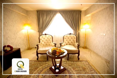 a room with two chairs and a table and a window at Qasr AlDur Hotel in An Najaf